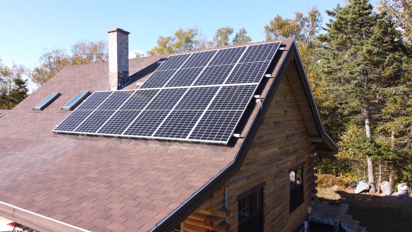 Completed solar project on the roof of a wood-sided home